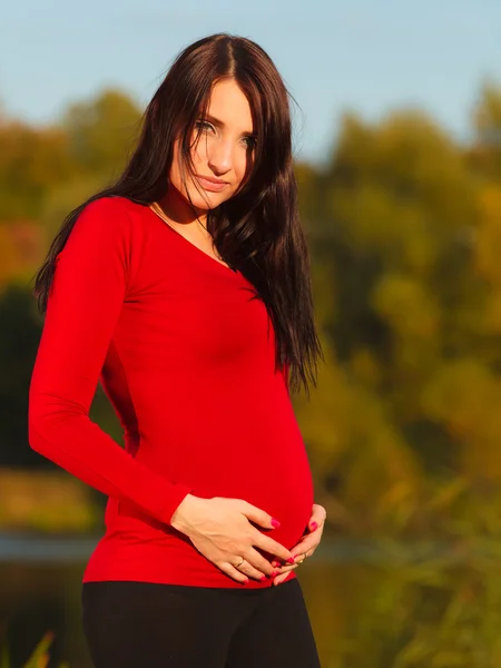 Расслабленная беременная женщина в парке на открытом воздухе — стоковое фото