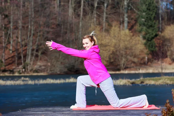 Donna adolescente in tuta da ginnastica facendo esercizio sul molo all'aperto — Foto Stock