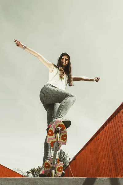 Девушка-фигуристка катается на скейтборде по улице. — стоковое фото