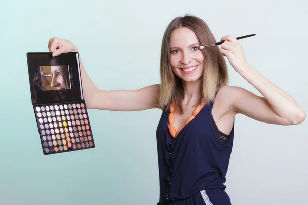 Mujer aplicando sombra de ojos con paleta de maquillaje . —  Fotos de Stock