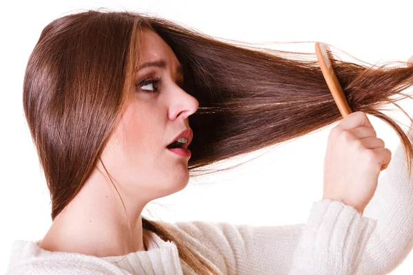 Woman combing and pulls hair. — Stock Photo, Image