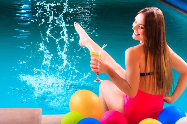 Happy woman with balloons and cocktail at poolside — Stock Photo, Image