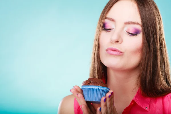 Leende kvinna håller chokladtårta i handen — Stockfoto