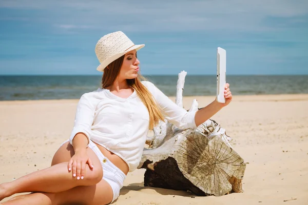 Mujer con tableta en la playa tomando selfie — Foto de Stock