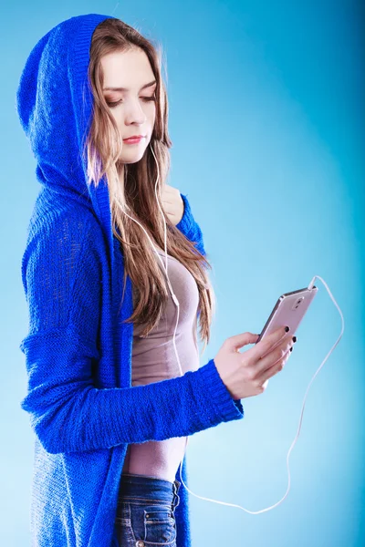 一个拿着智能手机听音乐的年轻女人 — 图库照片