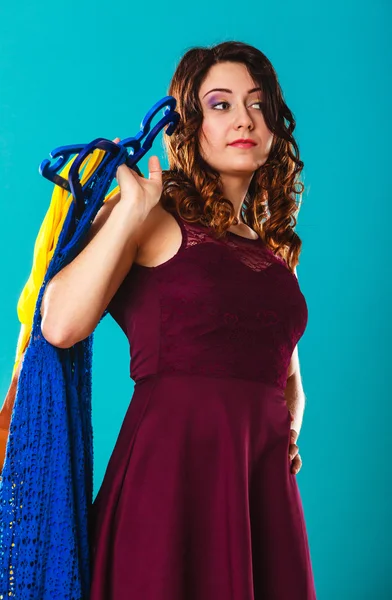 Woman customer holding hangers with clothes — Stock Photo, Image