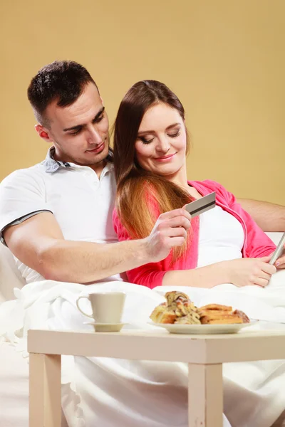 Young couple with tablet and credit card at home — Stock Photo, Image