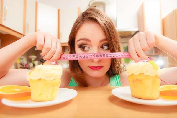 Mulher com fita métrica e bolo. Dilema da dieta . — Fotografia de Stock