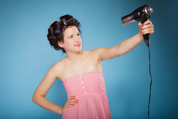 Saçı bukleli kız saç kurutma makinesi tutuyor. — Stok fotoğraf