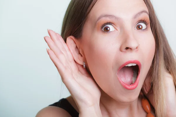 Geschocktes Klatschmädchen belauscht mit der Hand am Ohr. — Stockfoto