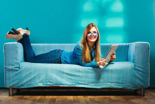 Mulher com tablet relaxante no sofá cor azul — Fotografia de Stock