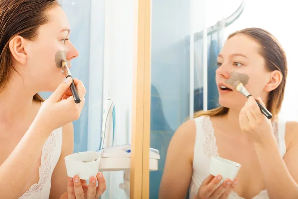 Mujer aplicando máscara facial de barro — Foto de Stock