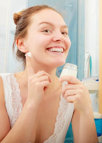 Mulher aplicando creme hidratante para a pele. Tratamento da pele . — Fotografia de Stock