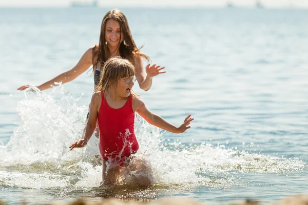 Niña y madre en agua de mar. Diversión — Foto de Stock