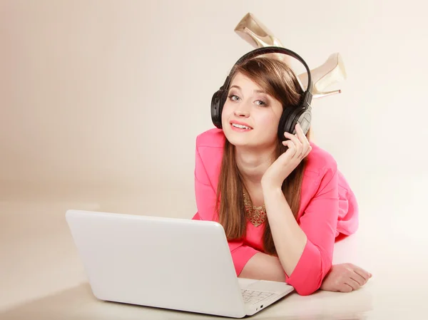 Девушка с наушниками и ноутбуком слушает музыку — стоковое фото