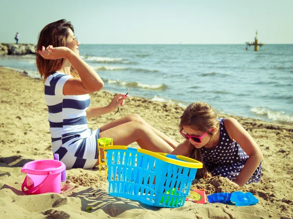 Family mother and daughter having fun on beach. — Stock Photo, Image