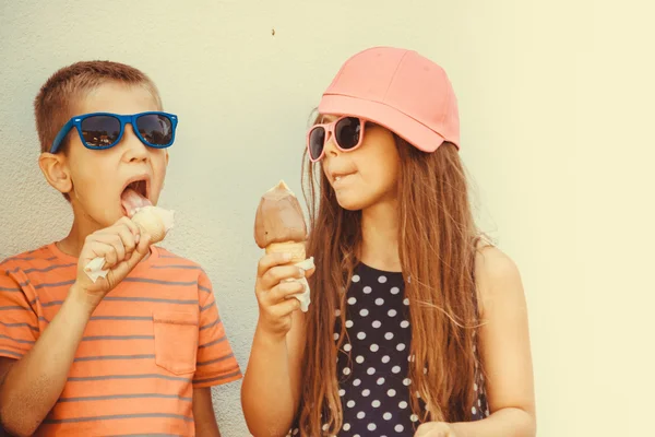 Niños niño y niña comiendo helado . — Foto de Stock