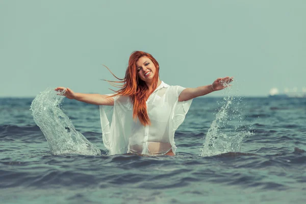 Chica salpicando agua en la costa. —  Fotos de Stock