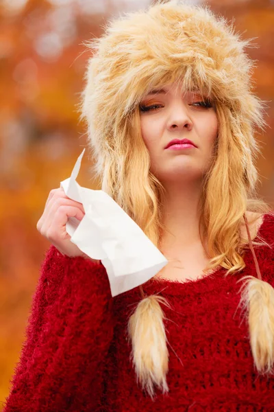 Sick woman in autumn park sneezing — Stock Photo, Image
