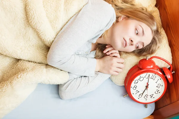 Unhappy woman waking up with alarm clock. — Stock Photo, Image