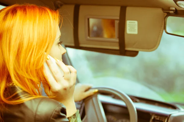 Девушка разговаривает по мобильному телефону во время вождения автомобиля . — стоковое фото