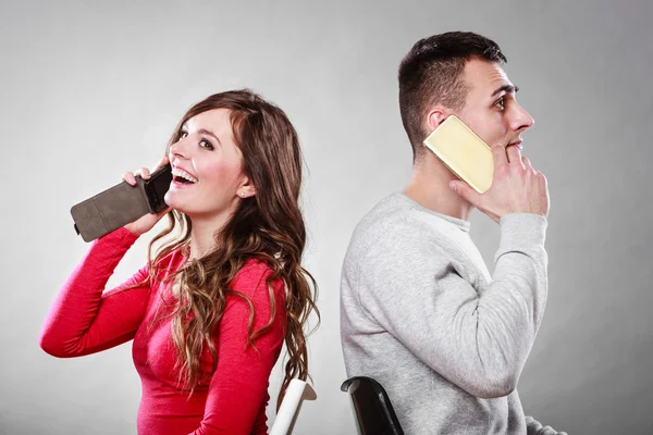 Jovem casal falando em telefones celulares. — Fotografia de Stock