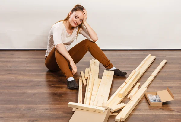 Worried woman assembling wooden furniture. DIY. — Stock Photo, Image