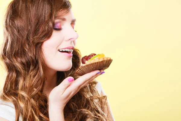 Woman closed eyes holds cake in hand — Stock Photo, Image