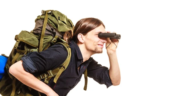 Muž turistické batohem při pohledu dalekohledem. — Stock fotografie