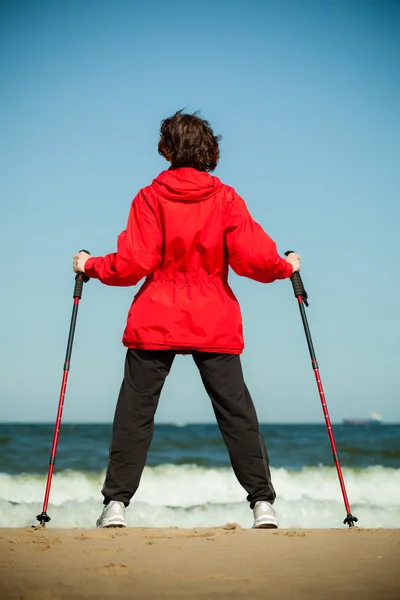 Nordic walking. Woman hiking on the beach. — Stock Photo, Image