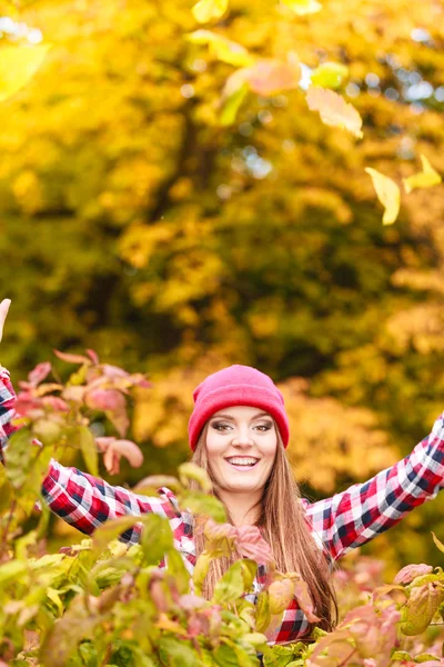 Frau im Herbstpark wirft Laub in die Luft — Stockfoto