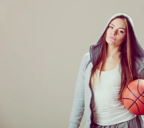 Kapüşonlu genç kız basketbol topunu tutuyor.. — Stok fotoğraf