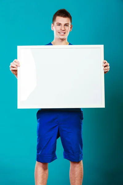 Muž, který držel prázdná prezentace desky na modré — Stock fotografie