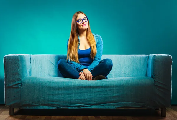 Модная девушка в джинсах сидит на диване . — стоковое фото