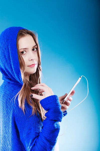 一个拿着智能手机听音乐的年轻女人 — 图库照片