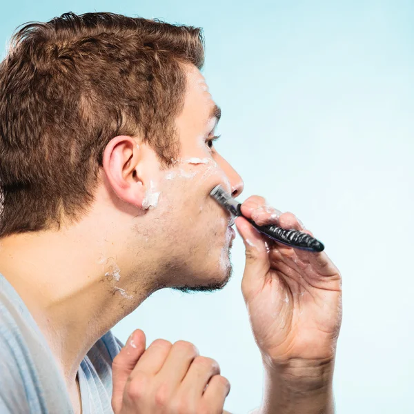 Man shaving with razor face profile — Stock Photo, Image