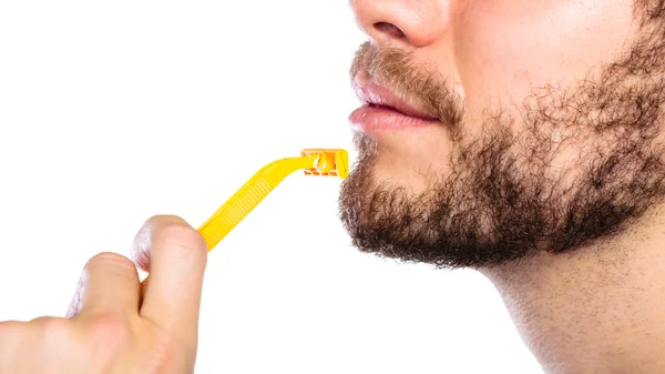 Young man with beard holding razor blade — Stock Photo, Image