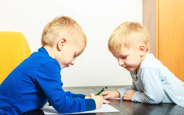 Dzieci chłopców z pisania piórem odrabiania lekcji. W domu. — Zdjęcie stockowe