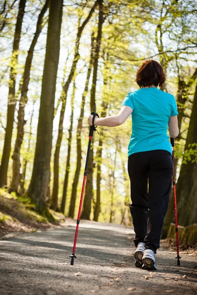 Nordic walking. Kobieta wędrująca po parku leśnym. — Zdjęcie stockowe