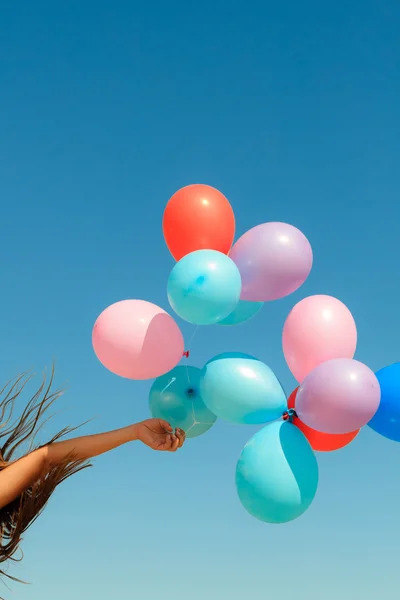 Mão segurando balões céu fundo — Fotografia de Stock