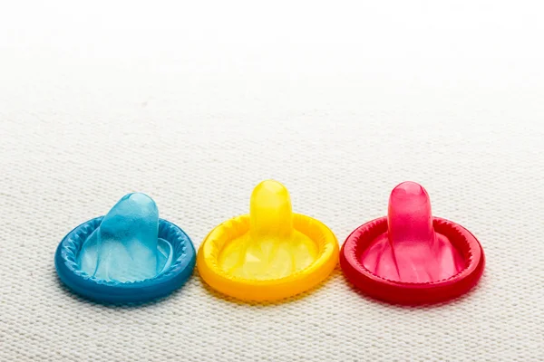 Kolorowy prezerwatywy na białym obrusem. — Zdjęcie stockowe