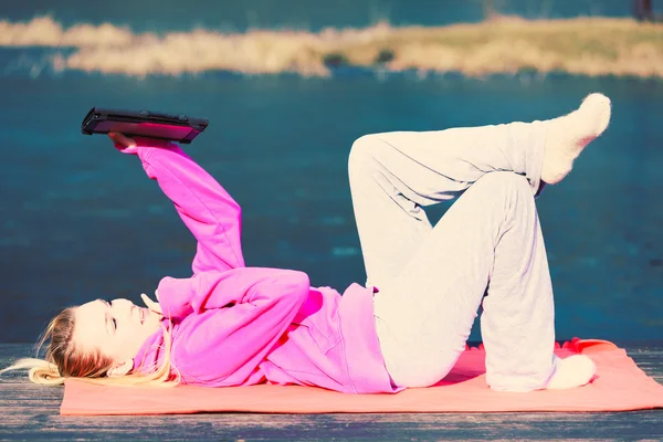 Girl lying in park using tablet. — Stock Photo, Image