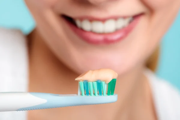 Mujer sostiene cepillo de dientes con pasta de dientes limpieza de dientes —  Fotos de Stock