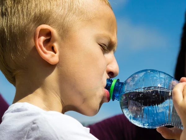 Beetje dorstig jongen kind drinkwater uit fles — Stockfoto