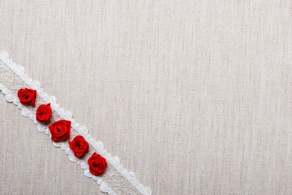 Marco de rosas de seda roja sobre tela — Foto de Stock