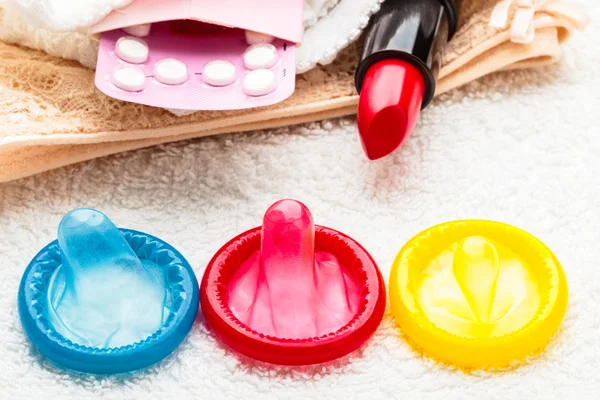 Таблетки презервативи і помада на мереживному білизні — стокове фото