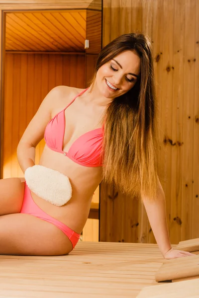 Woman in sauna with exfoliating glove. Skincare. — Stock Photo, Image