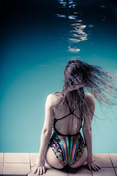 Woman back in swimsuit on pool edge. — Stock Photo, Image
