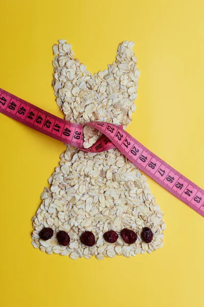 Dress shape made from oatmeal with measuring tape — Stock Photo, Image