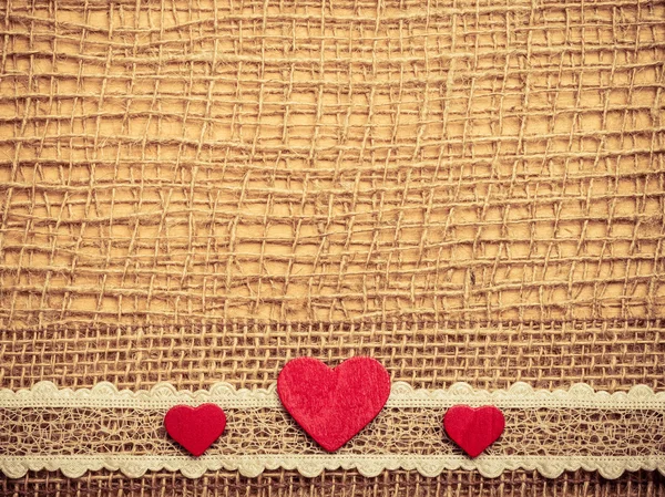 Soyut bez arka plan üzerinde kırmızı Kalpler — Stok fotoğraf